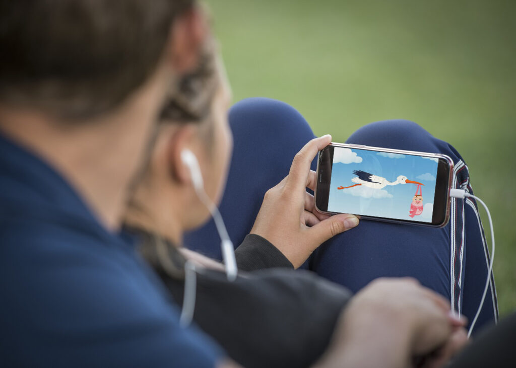 Young couple watching Stork new baby gift video Creative Ways to Use Funvidi Instant Video Gifts for Special Occasions Image of young couple watching a celebratory Stork video